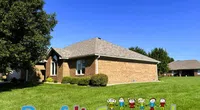 Single-story brick house under blue sky with green lawn and Roof It Forward graphic with children icons.