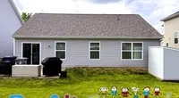 Backyard of a house with a gray roof and siding, green lawn, and colorful Roof It Forward logo with stick figures.