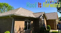 Brick house with a new shingle roof under clear blue sky and Roof It Forward logo with cartoon kids.