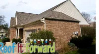 Brick house with shingled roof and bushes in front, featuring a Roof It Forward logo overlay.