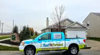 a Roof It Forward truck parked in front of a house