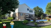 a house with a lawn and a cartoon character in front of it