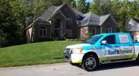 a Roof It Forward truck parked in front of a home