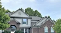 a large brick building with grass in front of a house
