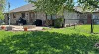 a backyard with a fence and a yard with a house in the background
