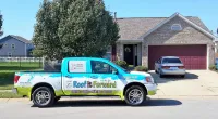 a Roof It Forward truck parked in front of a house