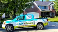 a Roof It Forward truck parked in front of a house