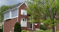 a large brick building with grass in front of a house