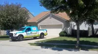 a Roof It Forward truck parked in front of a house