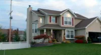 a close up of a green field in front of a house