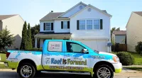 a Roof It Forward truck parked in front of a house