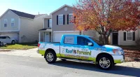a Roof It Forward truck parked in front of a home