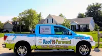a Roof It Forward truck parked in front of a house