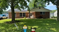 a couple of toy characters in a yard in front of a house