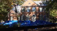 a house with a fence in front of a building