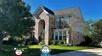 a house with a driveway and lawn with a cartoon character in front