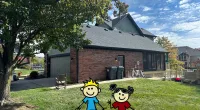 a couple of toy characters in a yard with a brick house and trees