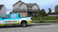 a Roof It Forward truck parked in front of a house