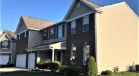 a large brick building with grass in front of a house