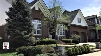 a large brick building with grass in front of a house