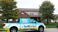 a Roof It Forward truck parked in front of a house