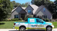 a Roof It Forward truck parked in front of a house