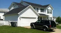 a car parked in front of a house with Southfork Ranch in the background