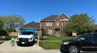 a black truck parked in front of a house
