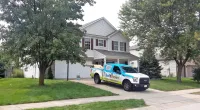 a Roof It Forward truck parked in front of a house