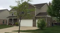 a tree in front of a customer's house