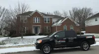 a Roof It Forward truck parked in front of a house