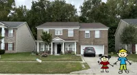 a house with a driveway and a lawn with a toy in front