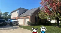 a house that has a sign on the side of a road