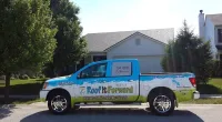 a Roof It Forward truck in front of the client's house