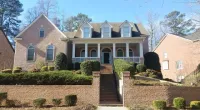 a large brick building with grass in front of a house