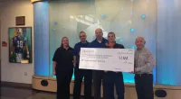 Roof It Forward employees holding a large check