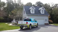 a Roof It Forward truck parked in front of a house
