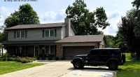 a black truck parked in front of a house with Meyer May House in the background