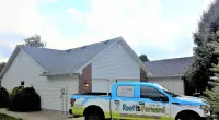 a Roof It Forward truck parked in front of a house