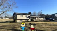a couple of toy characters in a yard with a house in the background