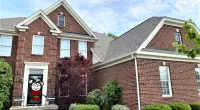 a large brick building with grass in front of a house