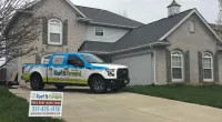 a Roof It Forward truck parked in front of a house