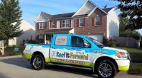a Roof It Forward truck parked in front of a house