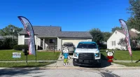 a car parked in front of a house with a cartoon character