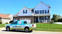 a Roof It Forward truck parked in front of a house