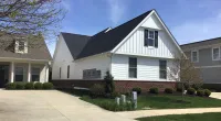 a large brick building with grass in front of a house