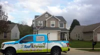 a Roof It Forward truck parked in front of a home