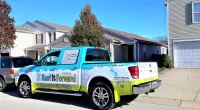 a Roof It Forward truck parked in front of a house