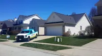 a Roof It Forward truck parked in front of a customer's home