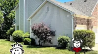 a house that has a sign on a grassy field